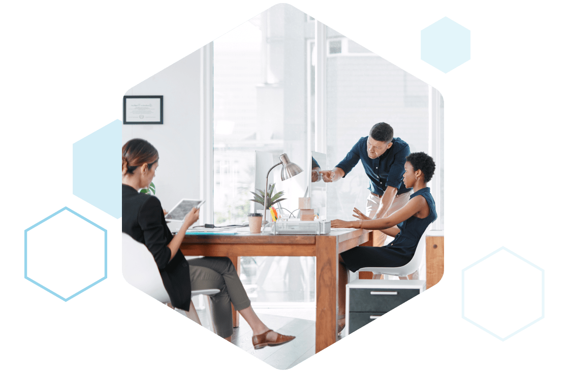 Employees collaborating in a work environment, discussing tech performance and analyzing data to improve results.